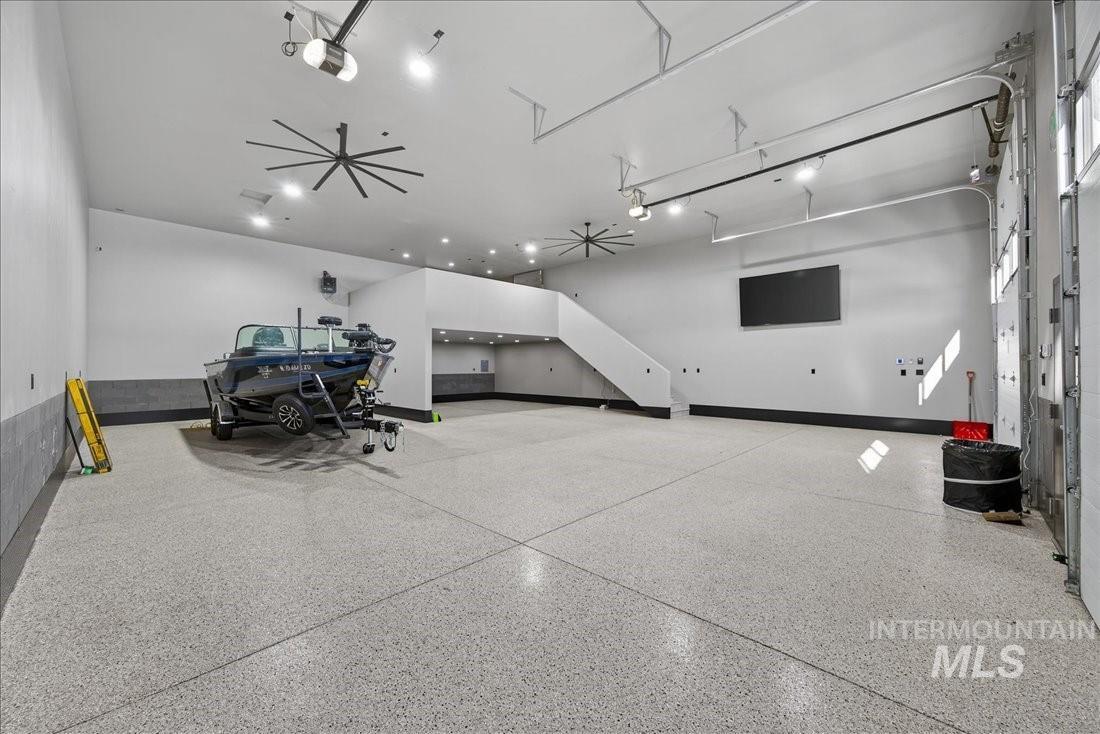 Garage featuring a garage door opener and baseboards