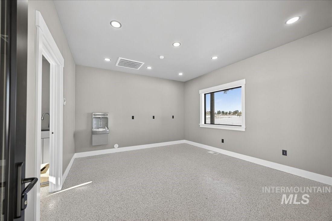 Spare room featuring recessed lighting and dark speckled floor