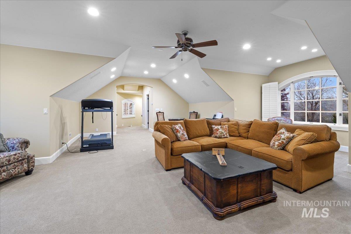 Living room with vaulted ceiling, recessed lighting, light colored carpet, and ceiling fan