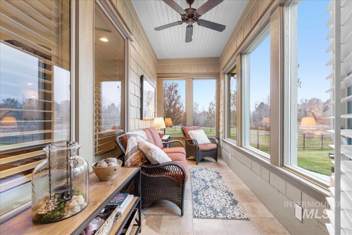 Sunroom with tile patterned flooring and wood walls