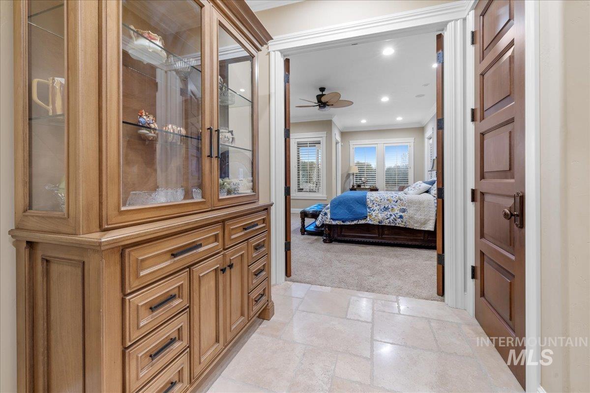 Hallway featuring ornamental molding, stone tile floors, light carpet, and recessed lighting
