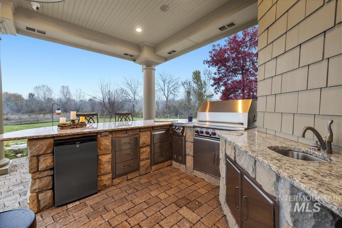 View of patio with exterior kitchen and a sink