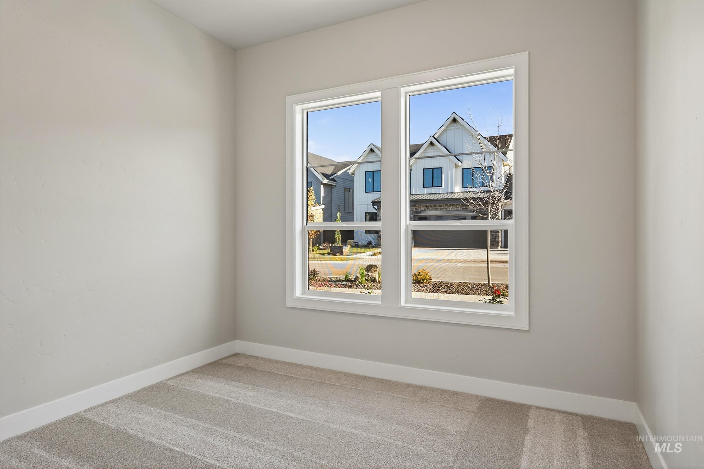 Carpeted spare room with baseboards