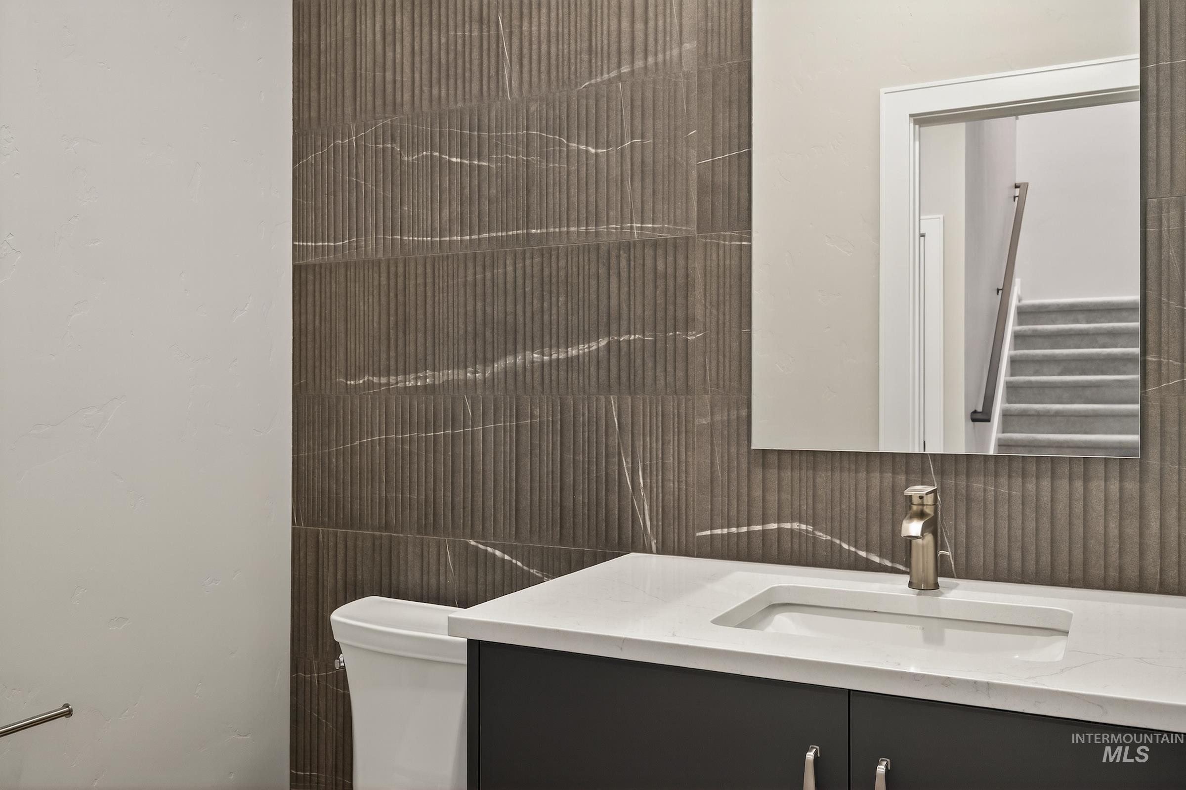 Half bathroom featuring vanity and toilet