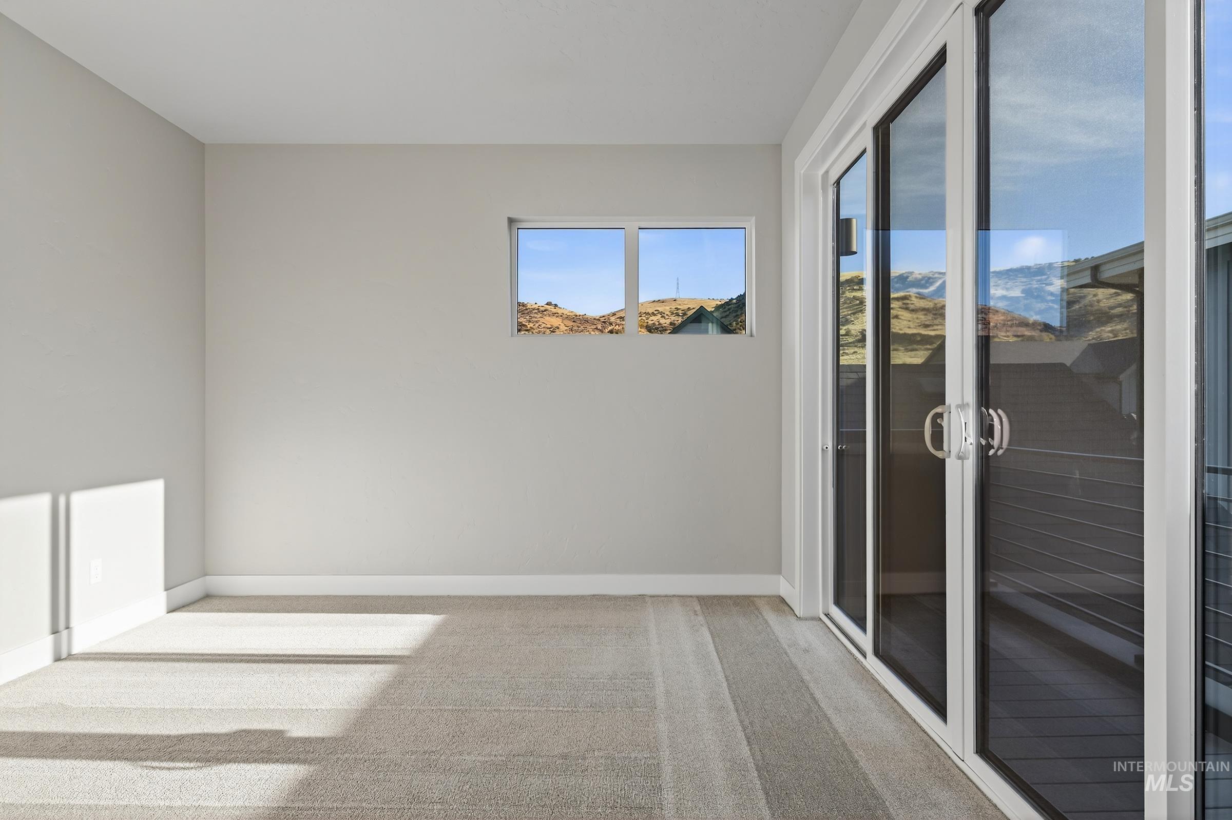 Unfurnished room with light carpet and a mountain view