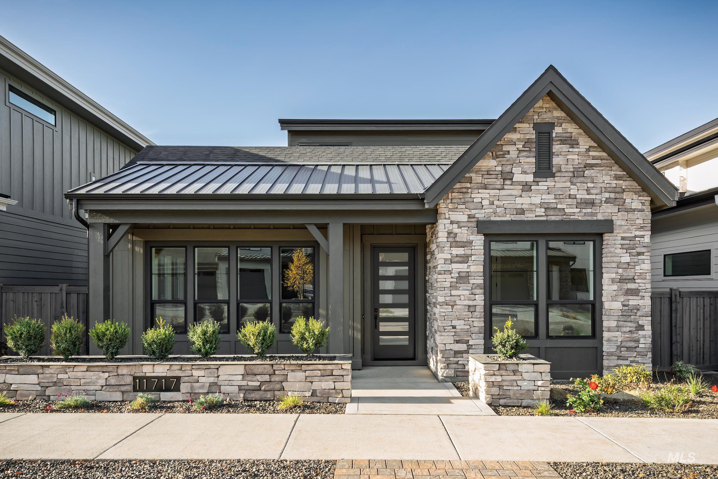 View of front of property featuring a standing seam roof, a metal roof, and stone siding