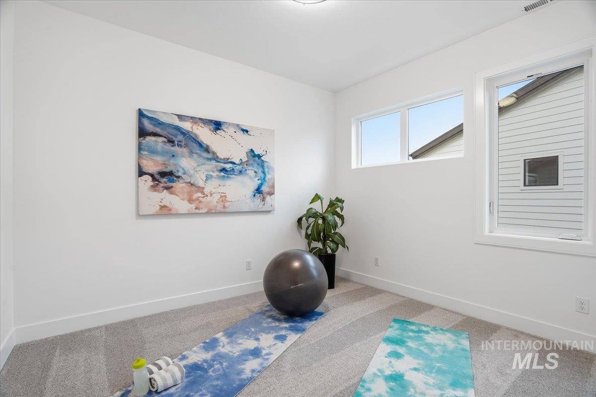Exercise room with carpet and baseboards
