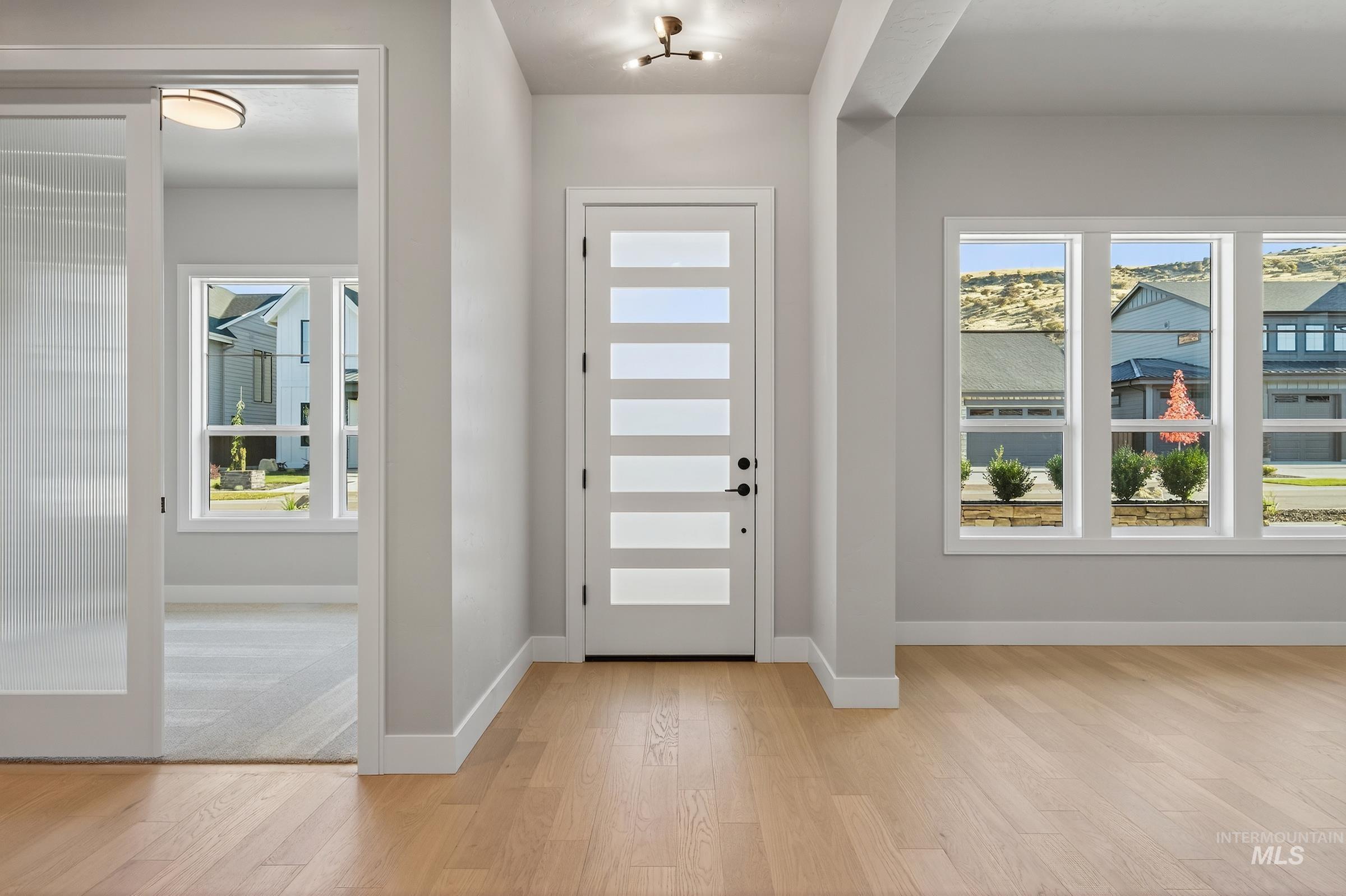 Foyer entrance with baseboards and light wood-type flooring