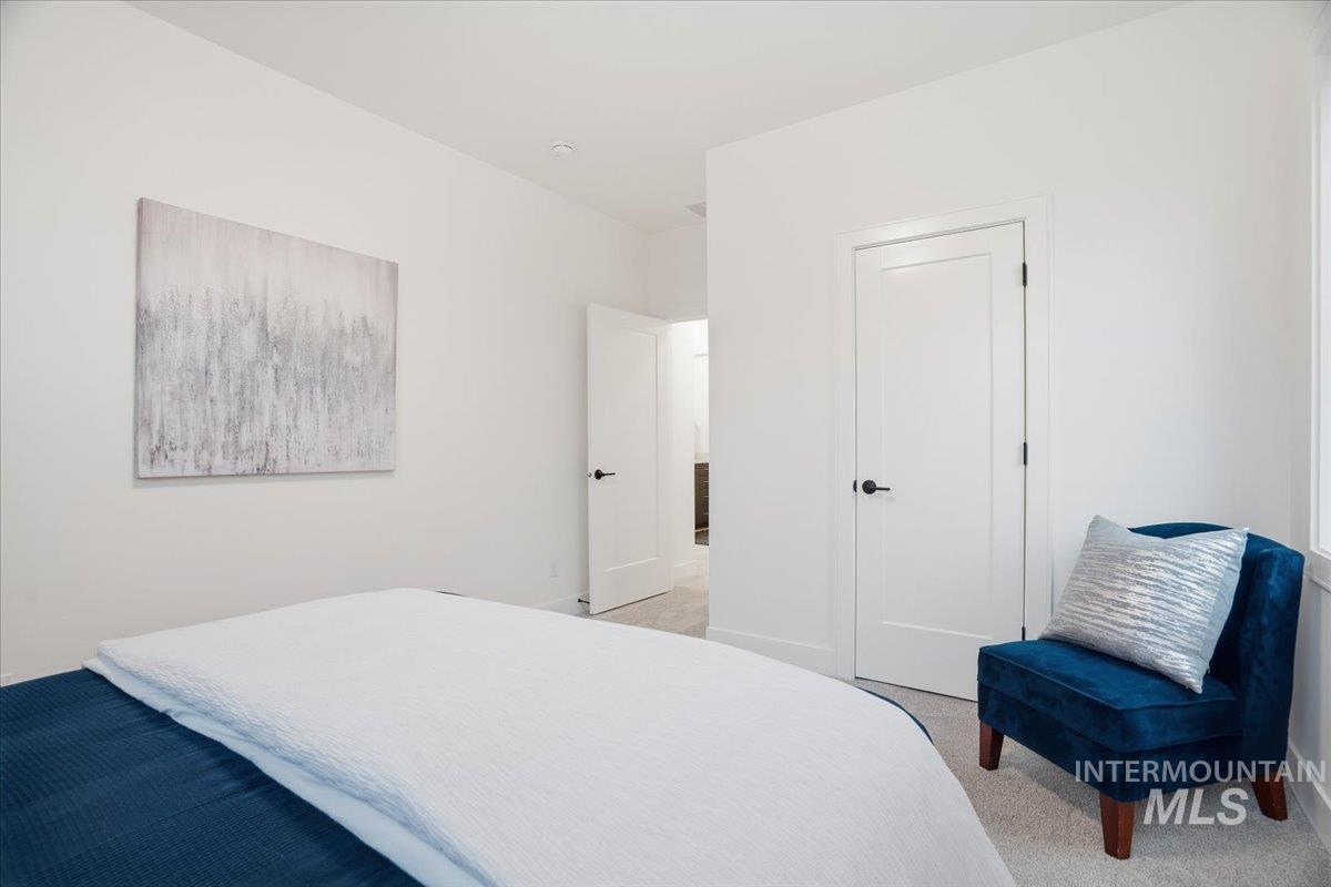 Bedroom featuring light carpet and baseboards