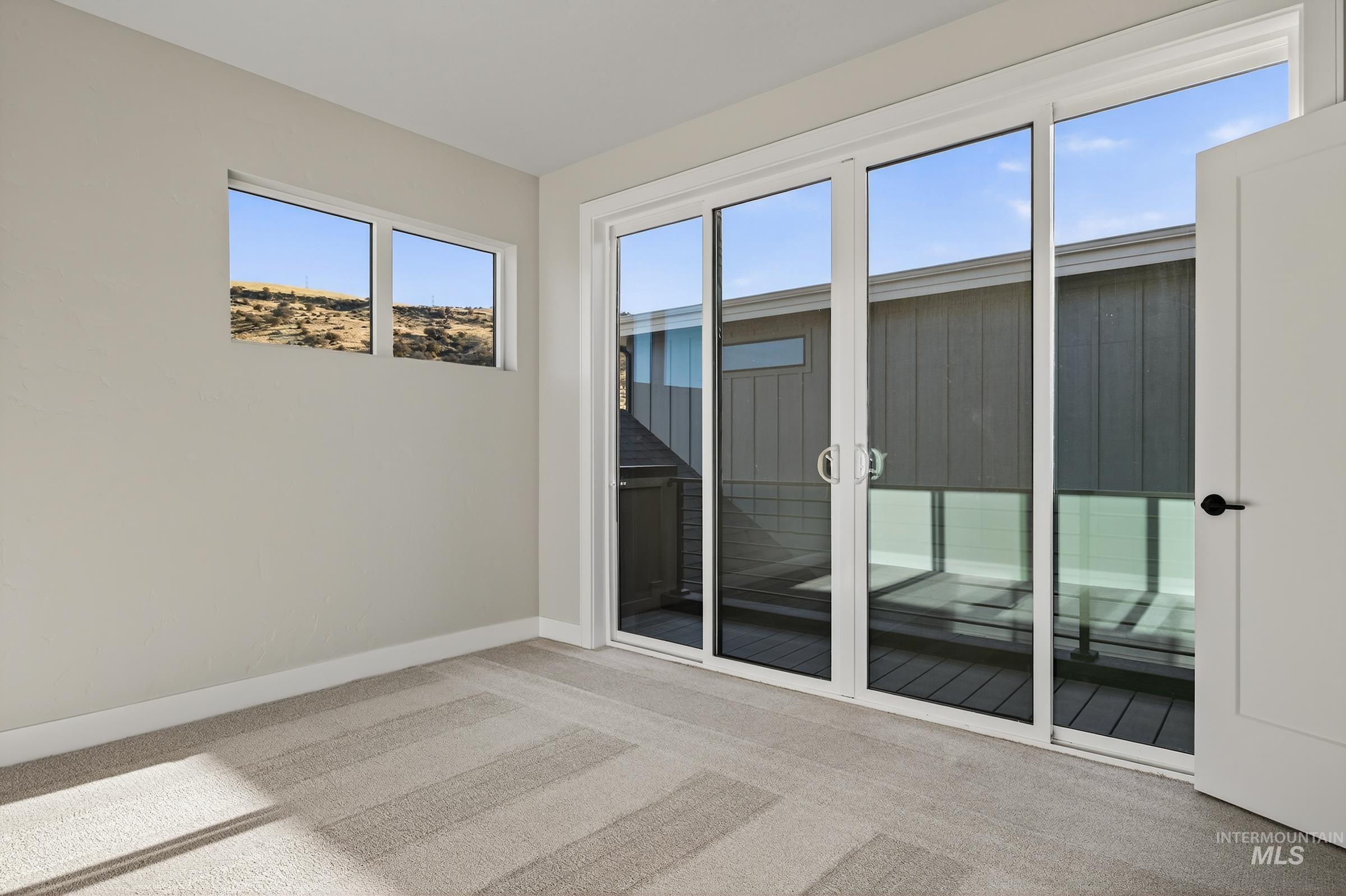 Spare room featuring light carpet and healthy amount of natural light