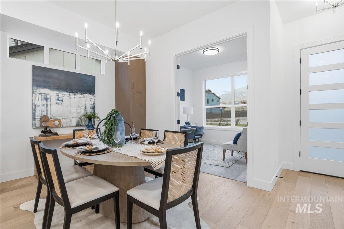Dining space with light wood-style flooring and a chandelier