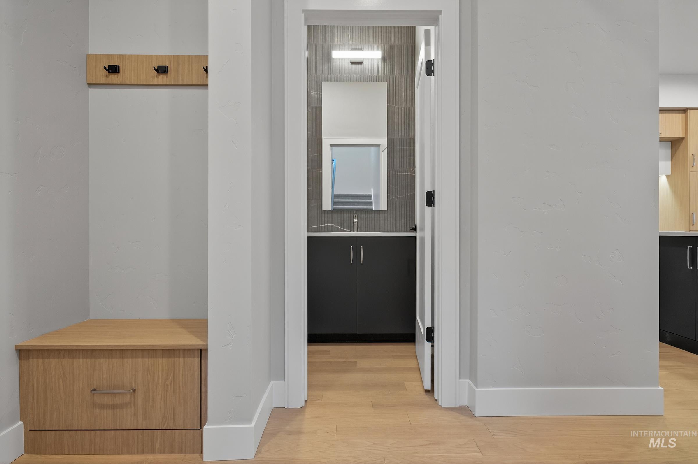 Corridor with light wood-style flooring and baseboards