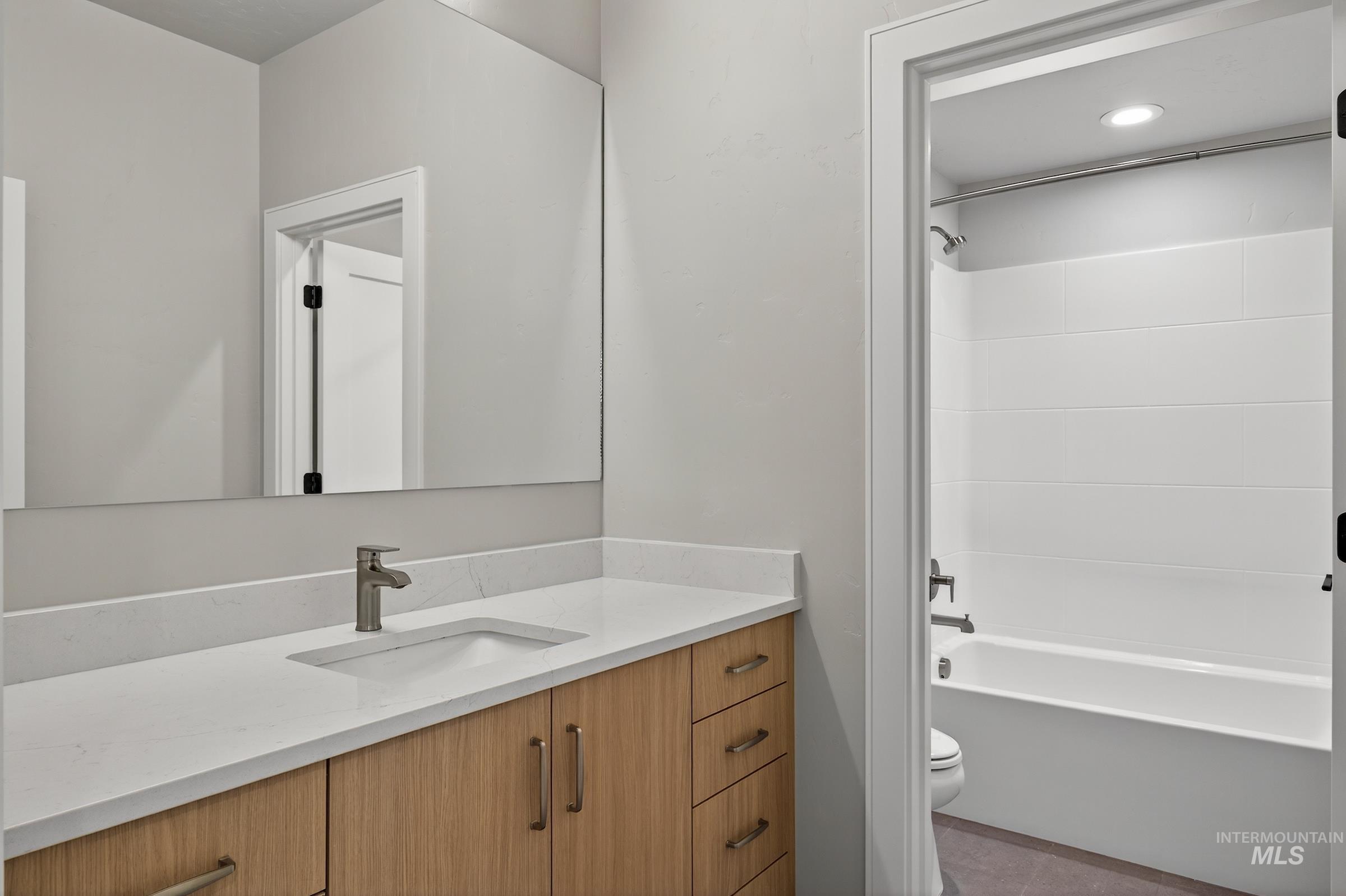 Bathroom with vanity, bathing tub / shower combination, and tile patterned floors