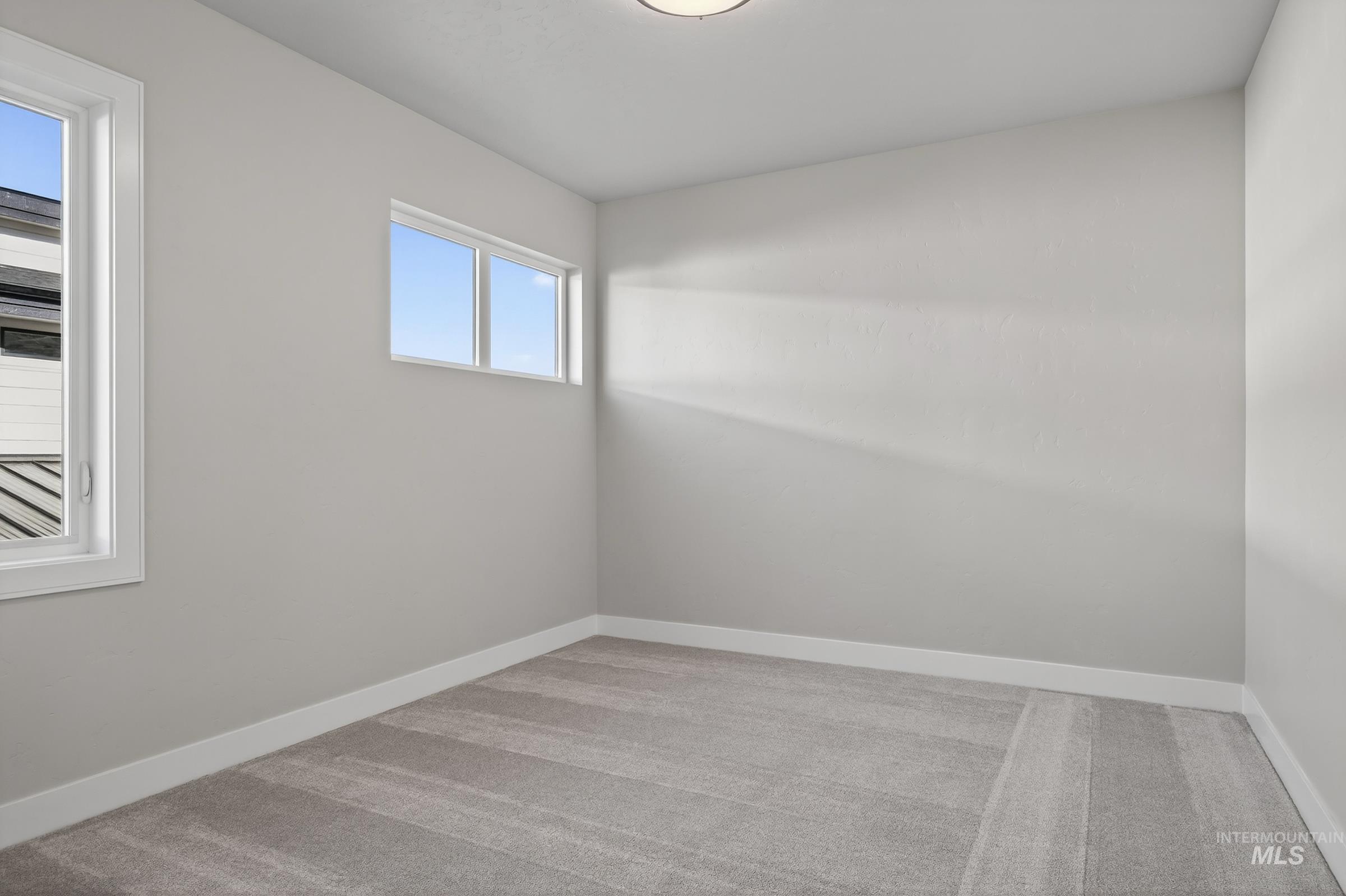 Unfurnished room featuring light colored carpet and baseboards