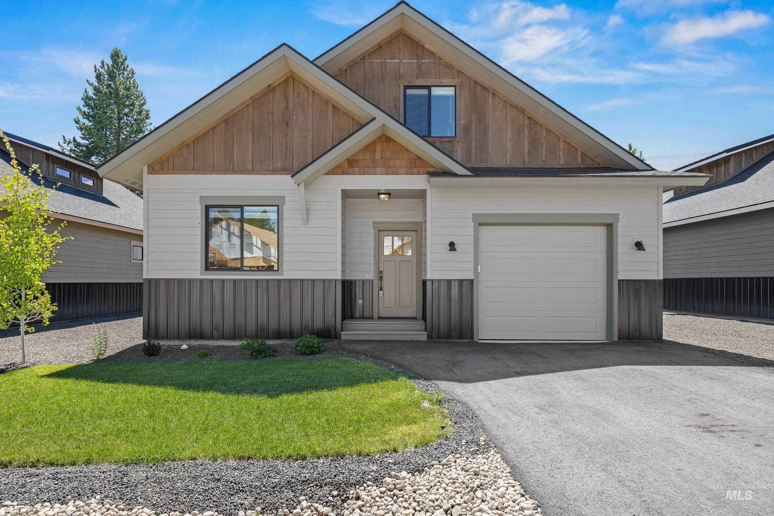 View of front facade with asphalt driveway, a front yard, and a garage