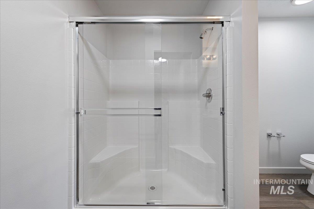 Bathroom with a stall shower and dark wood finished floors