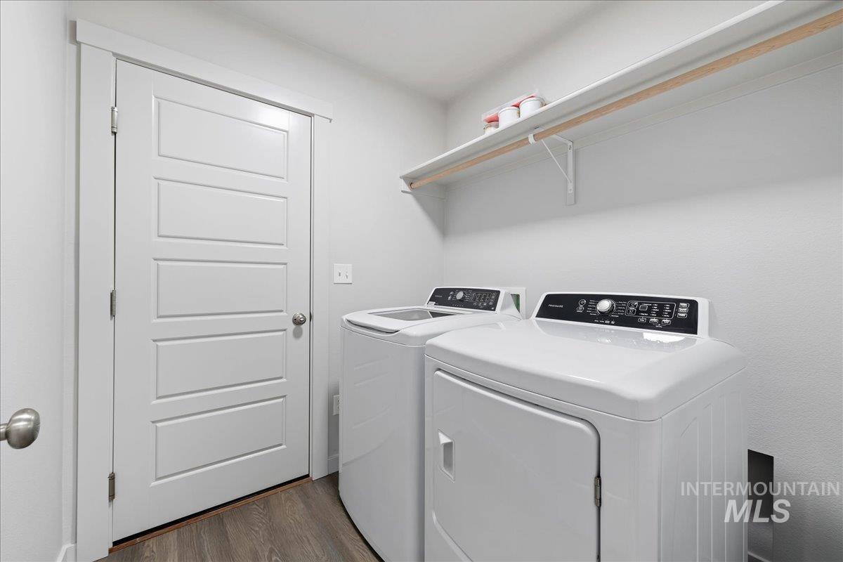 Laundry room featuring dark wood-style flooring and washer and clothes dryer