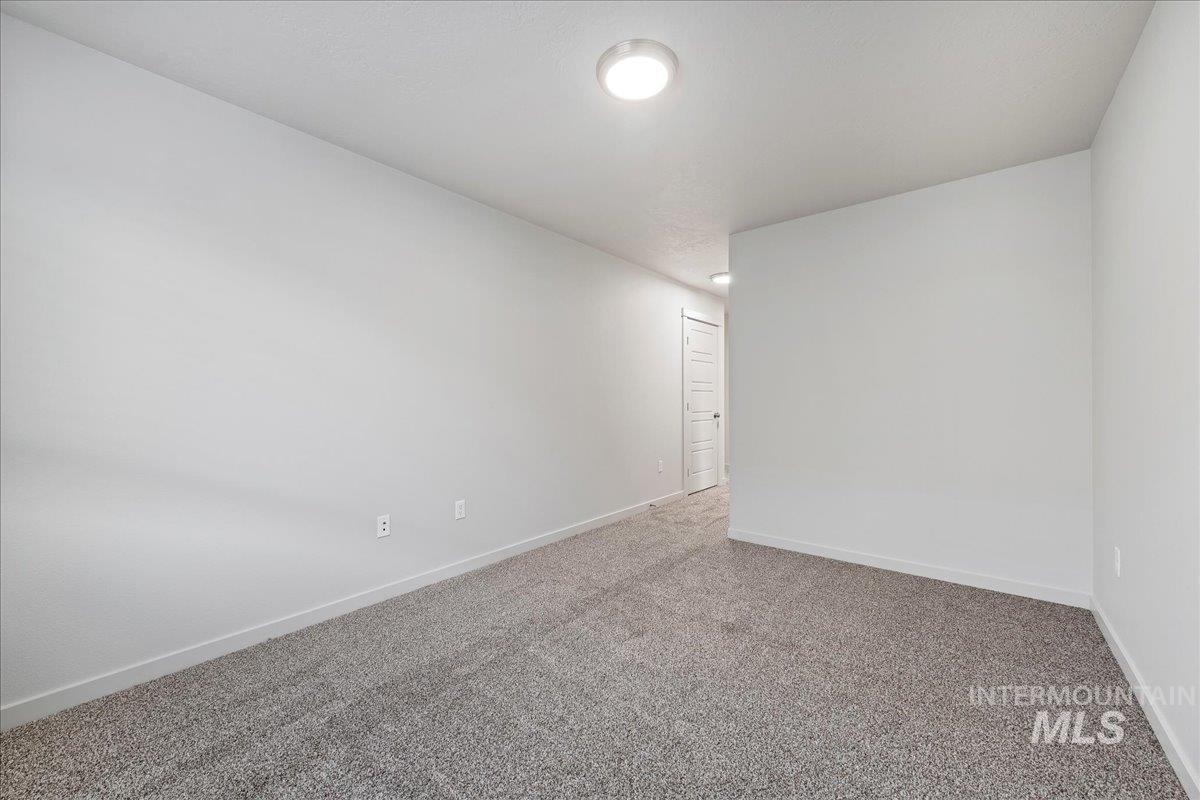 Empty room with carpet flooring and baseboards