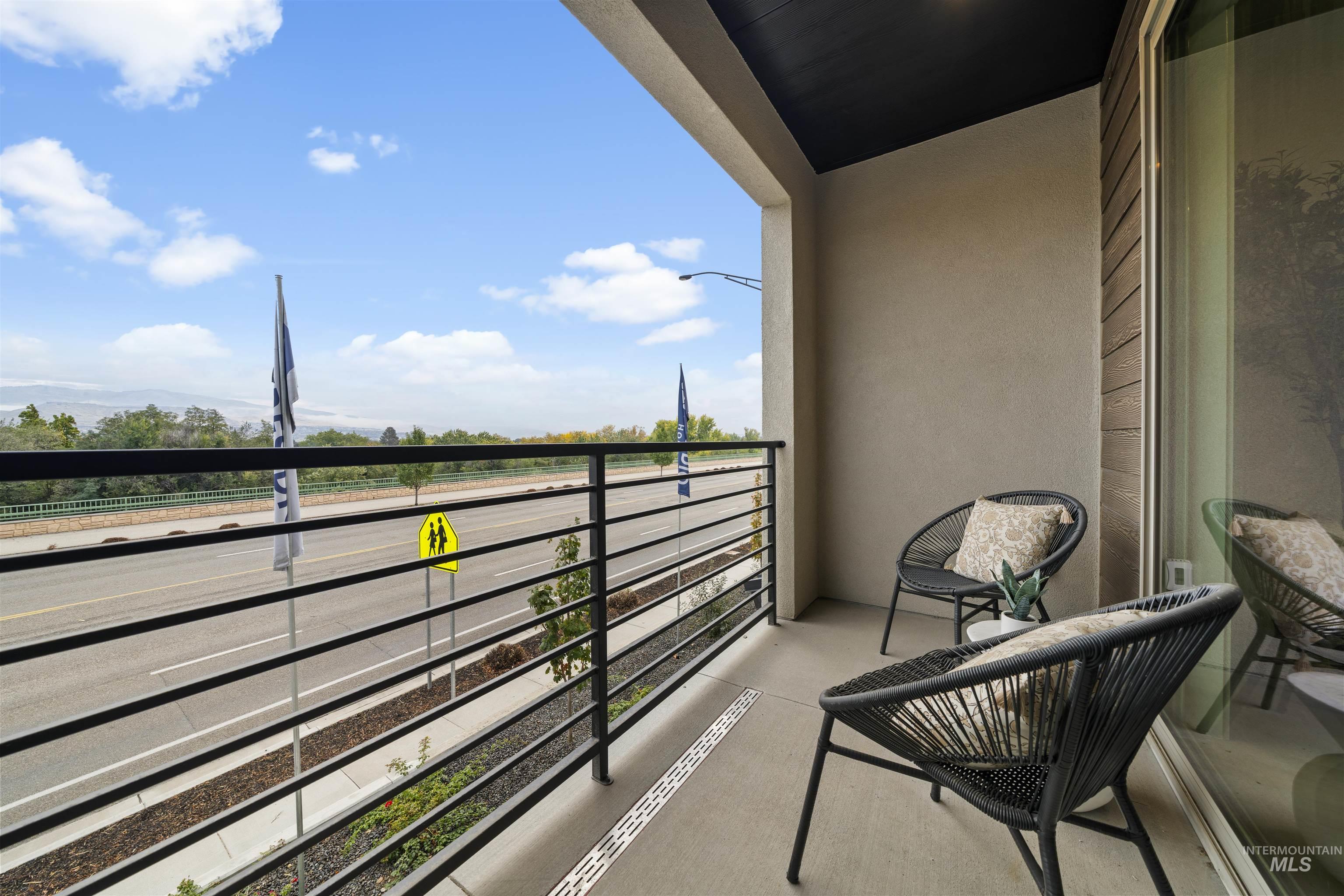 Private balcony featuring a concrete floor, black metal railing, and stucco exterior walls