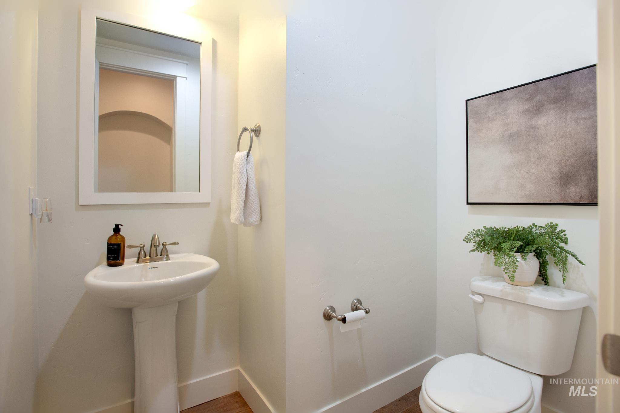 Half bathroom with baseboards and toilet