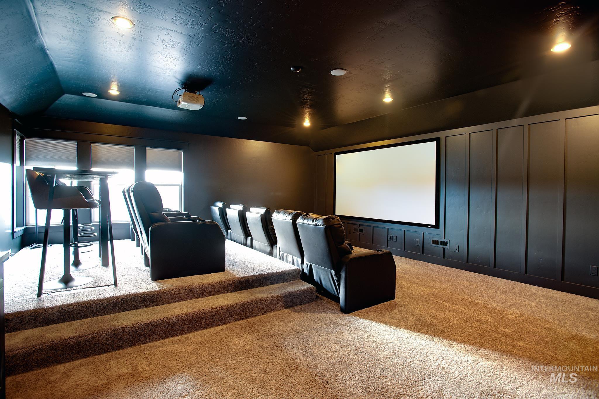 Cinema room featuring carpet flooring, vaulted ceiling, recessed lighting, and a decorative wall