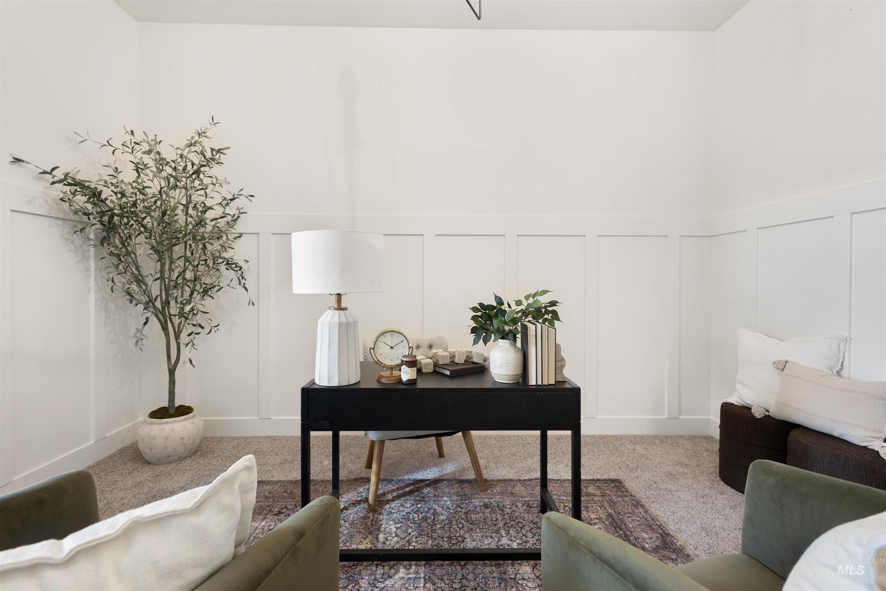 Carpeted office space featuring a decorative wall and wainscoting