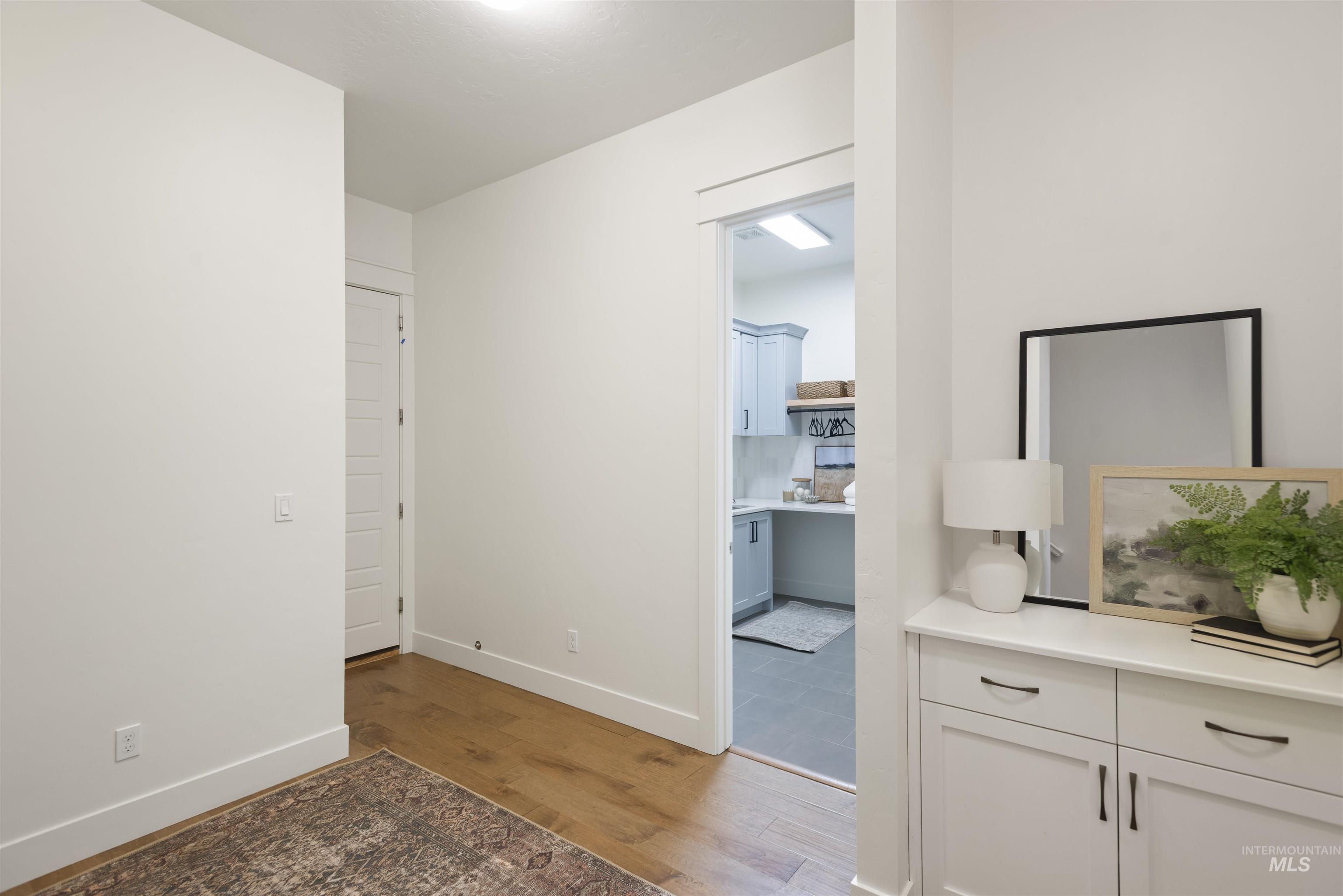 Hallway featuring dark wood-style floors and baseboards