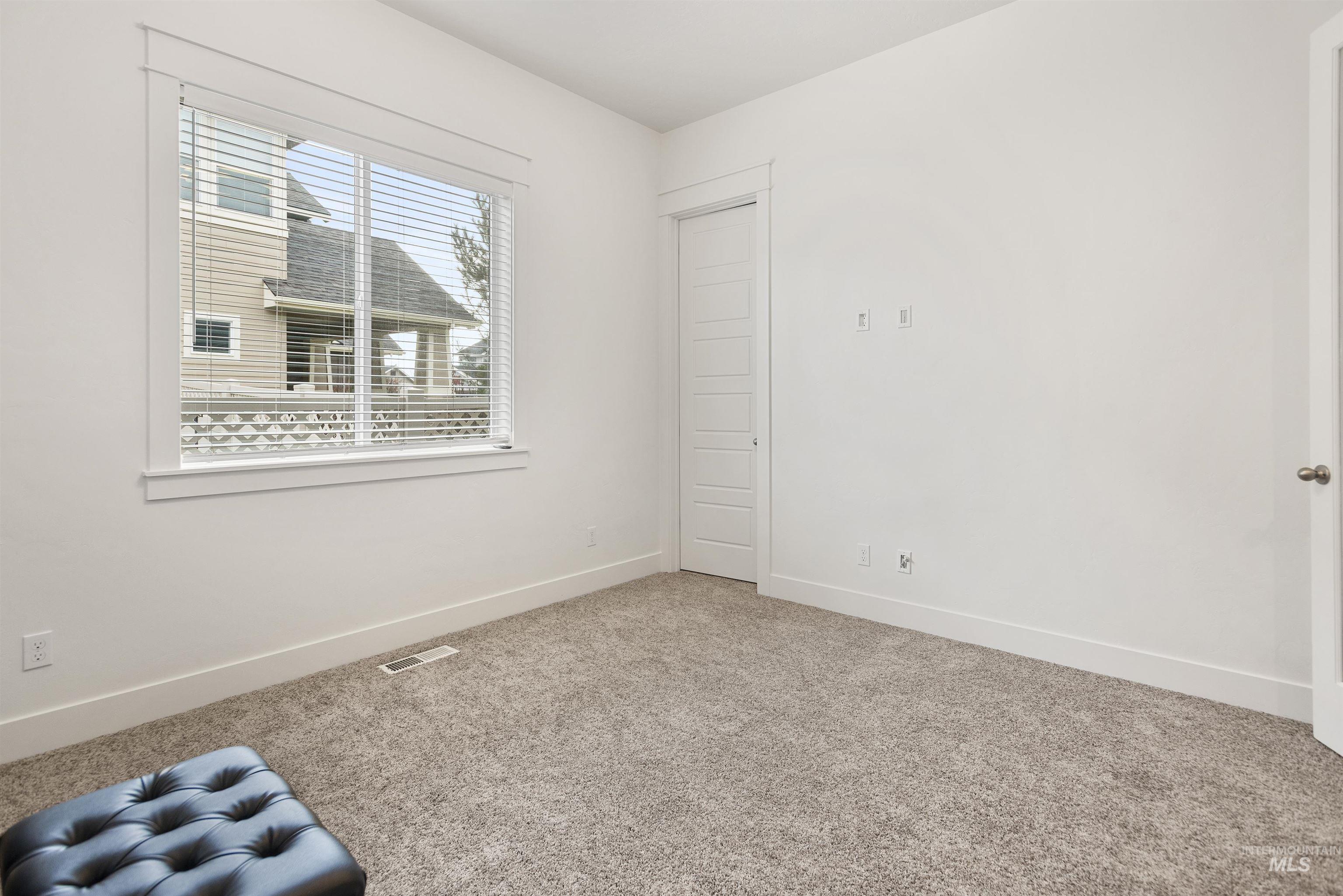 Unfurnished room featuring light carpet and baseboards