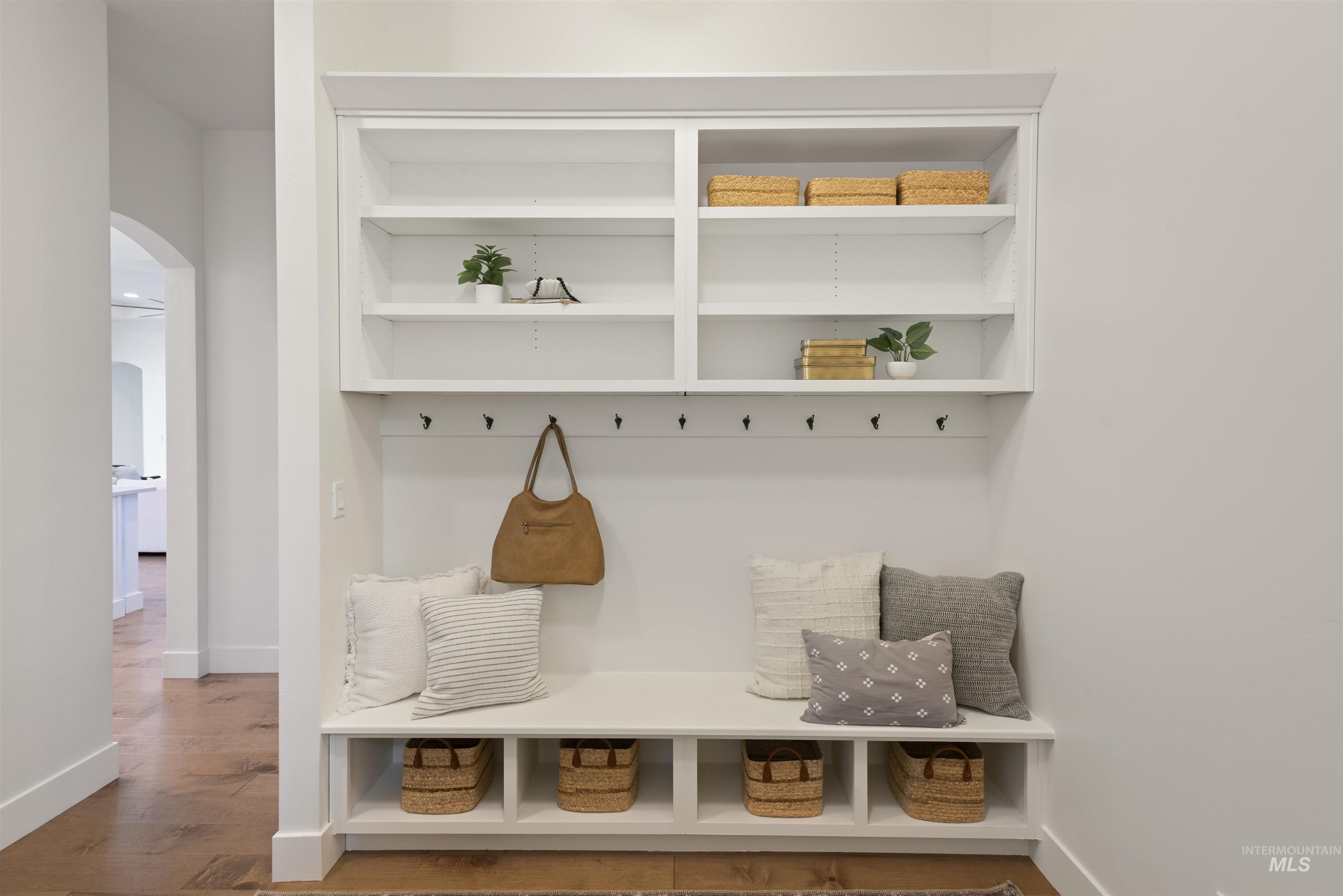Mudroom with arched walkways and wood finished floors