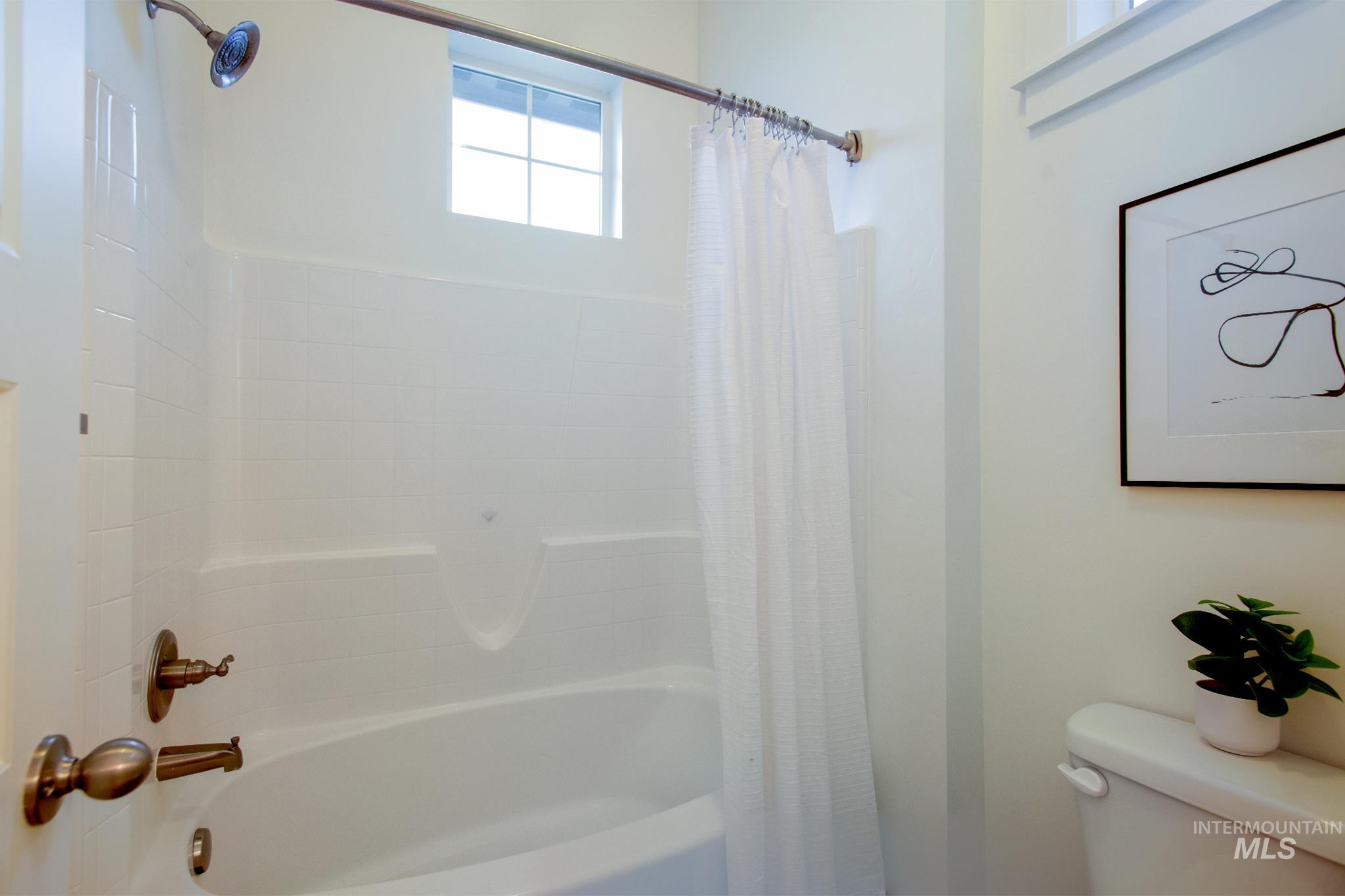 Full bath with toilet and shower / bathtub combination with curtain