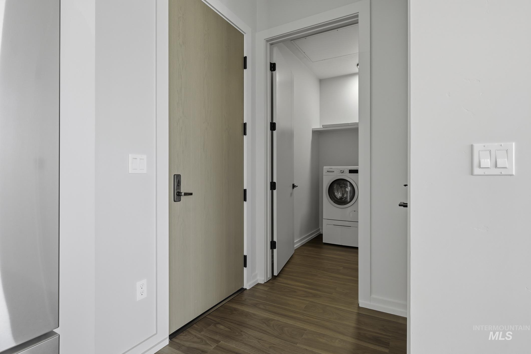 Hallway featuring washer / dryer and dark wood-style floors