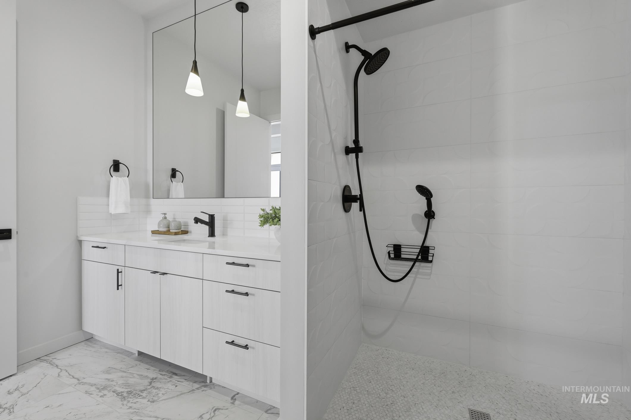 Full bathroom with vanity, a walk in shower, light marble finish floors, and decorative backsplash