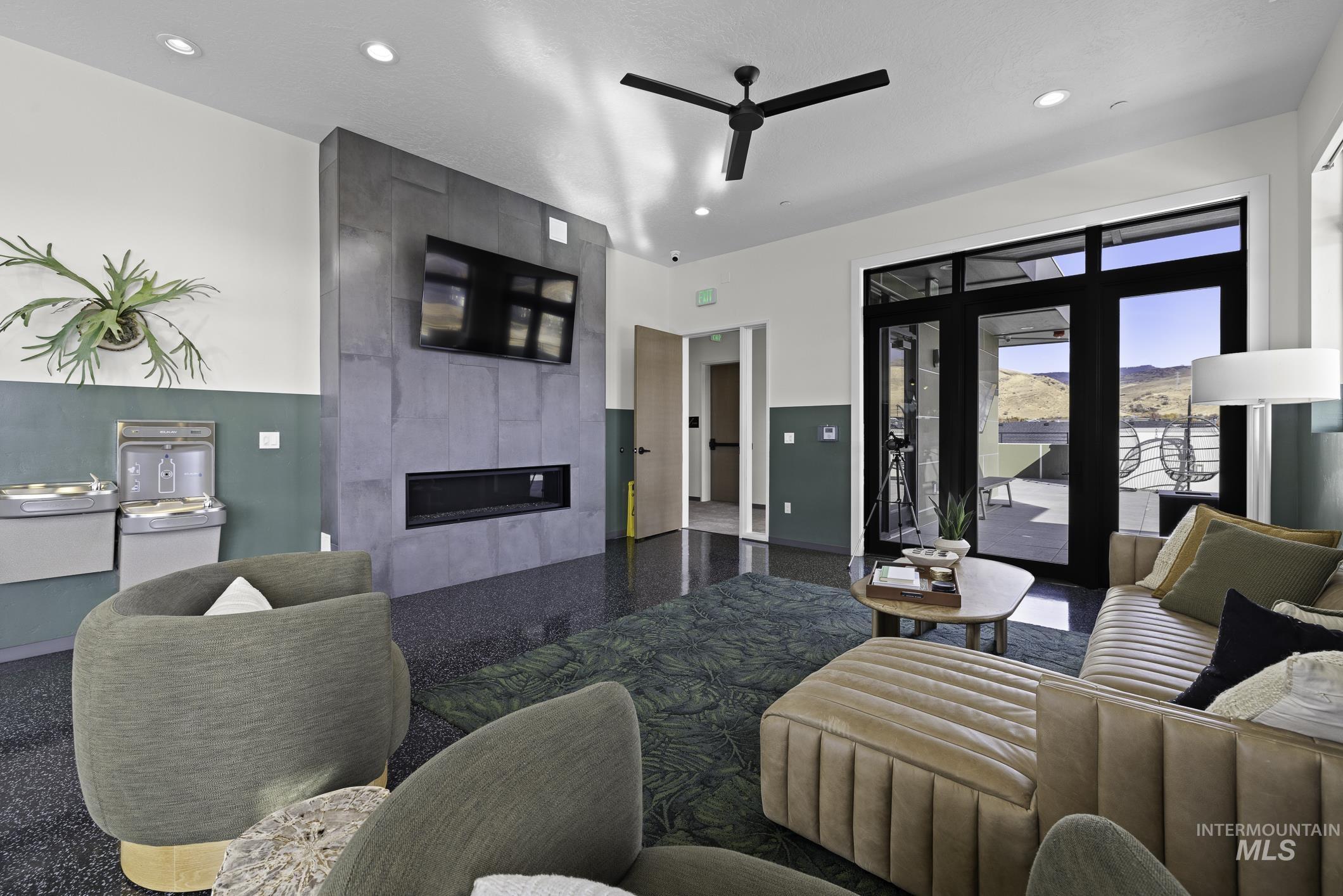 Living area with a large fireplace, a ceiling fan, and recessed lighting