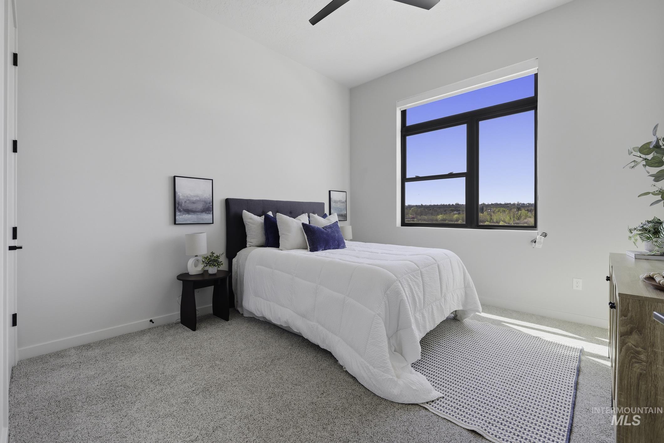 Bedroom with light colored carpet and a ceiling fan