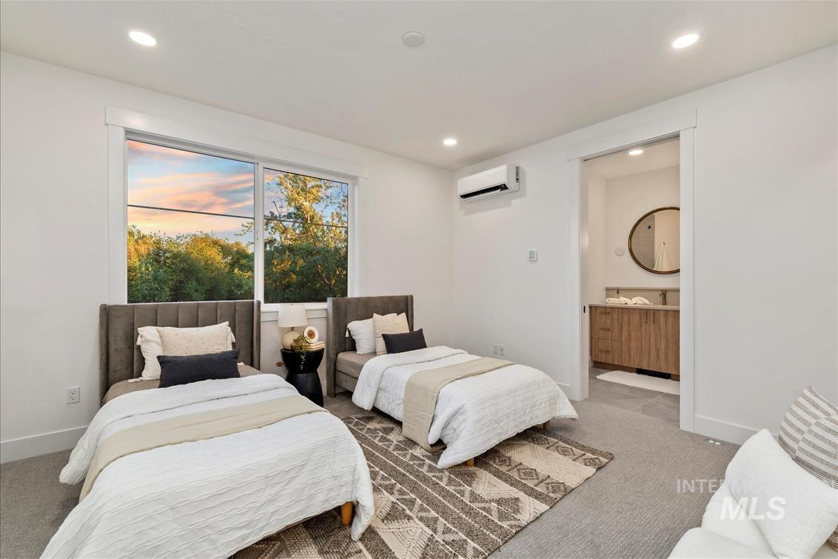 Carpeted bedroom featuring recessed lighting, a wall unit AC, and ensuite bath
