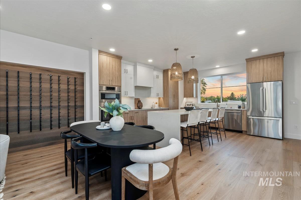 Dining area featuring light wood-style flooring, recessed lighting, and a chandelier