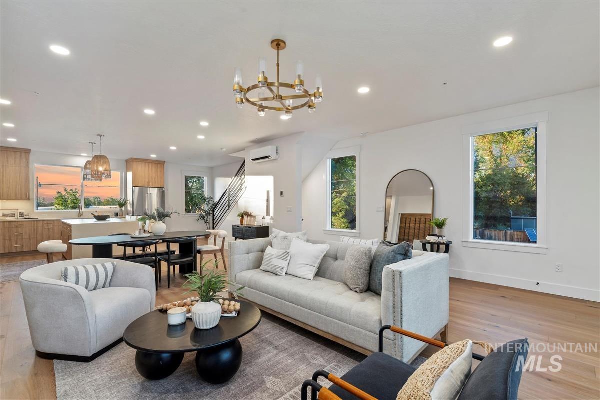 Living area featuring light wood-style floors, a chandelier, recessed lighting, and healthy amount of natural light