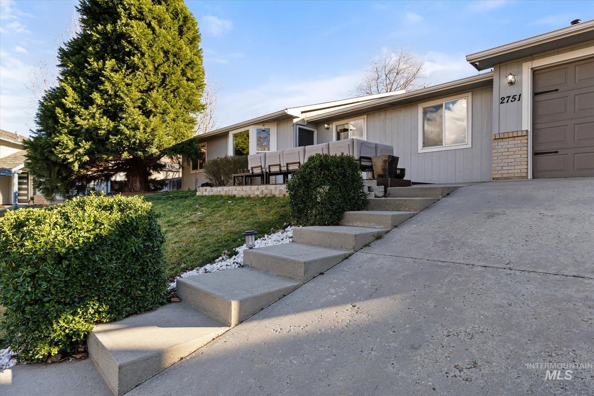 View of front of home with a front yard, a garage, and driveway