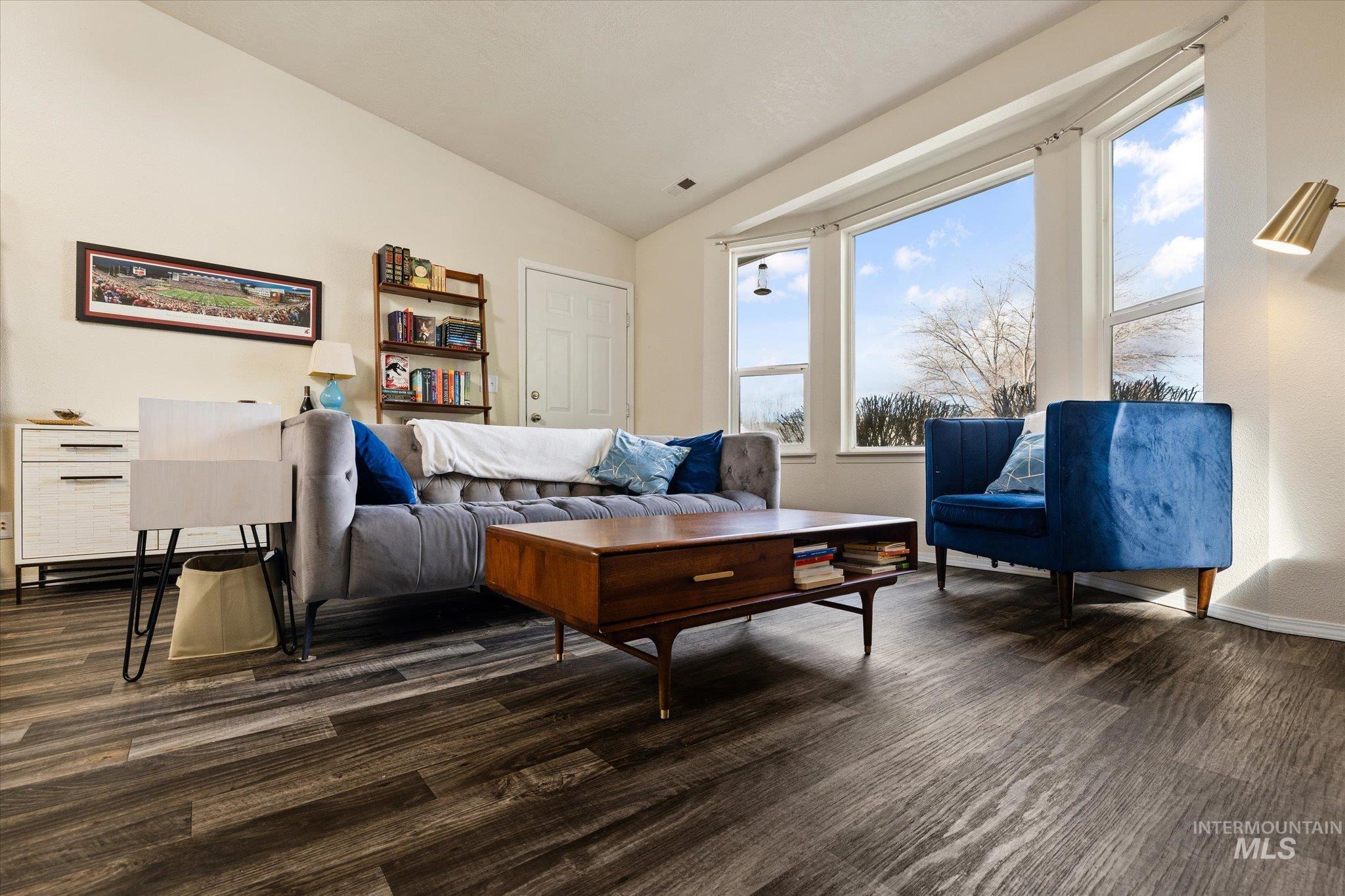 Living room with lofted ceiling and dark wood-style floors