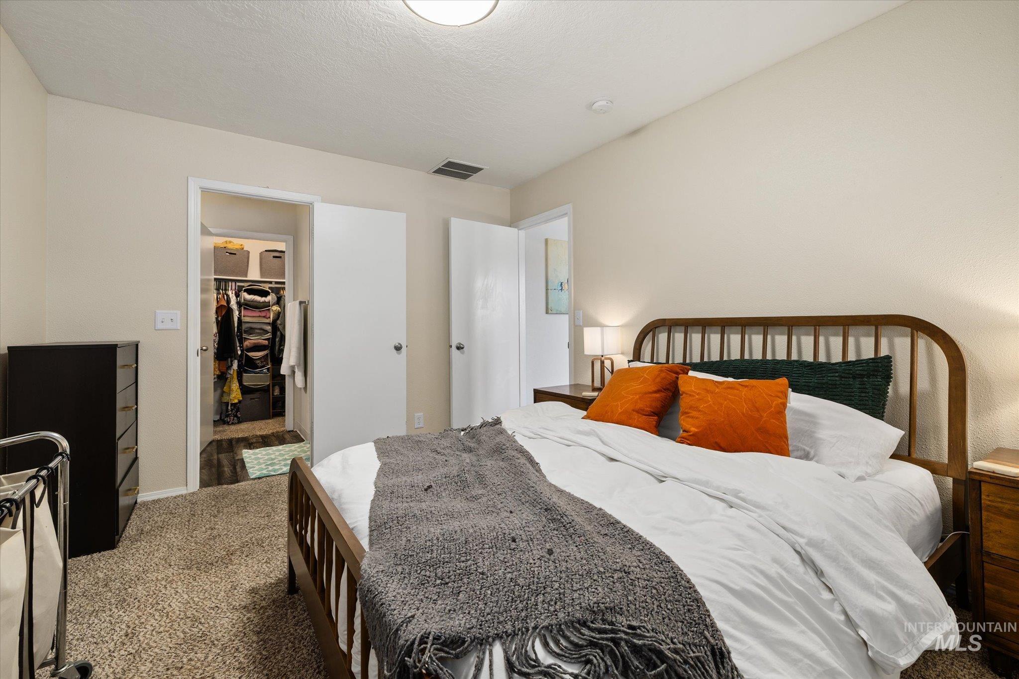 Carpeted bedroom with a spacious closet and baseboards