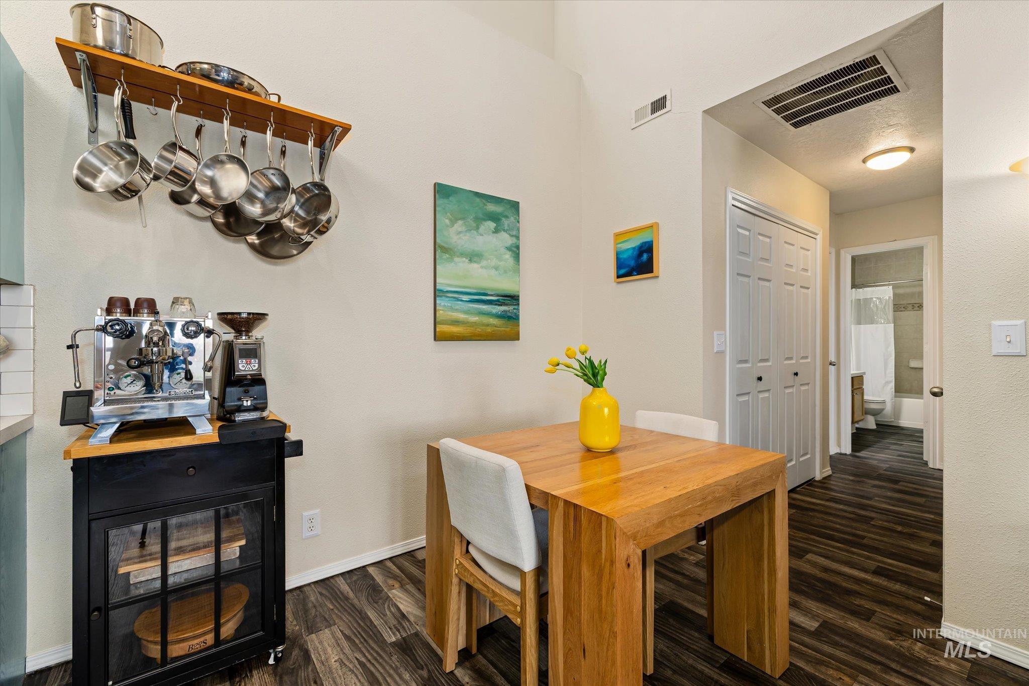 Dining area with dark wood-style flooring and baseboards