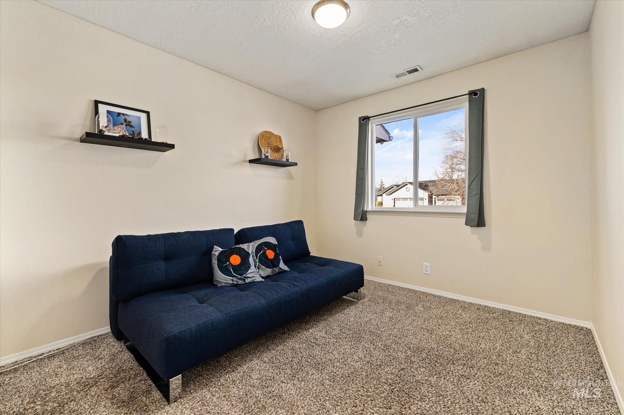 Living area featuring carpet flooring and a textured ceiling