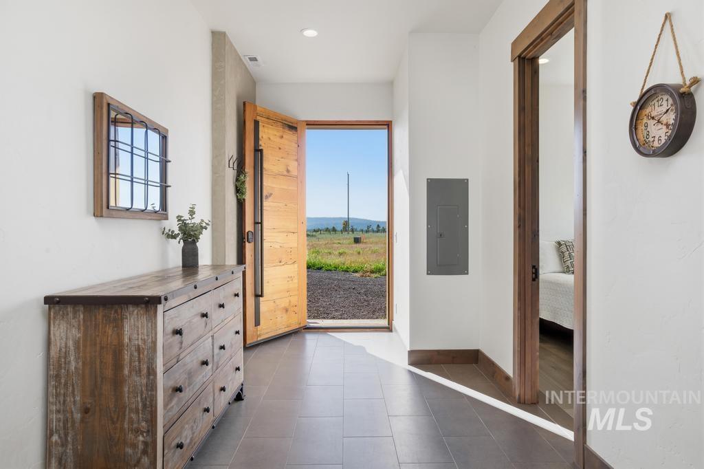 Entryway featuring a solid wood door with dark hardware, recessed lighting, and tile flooring