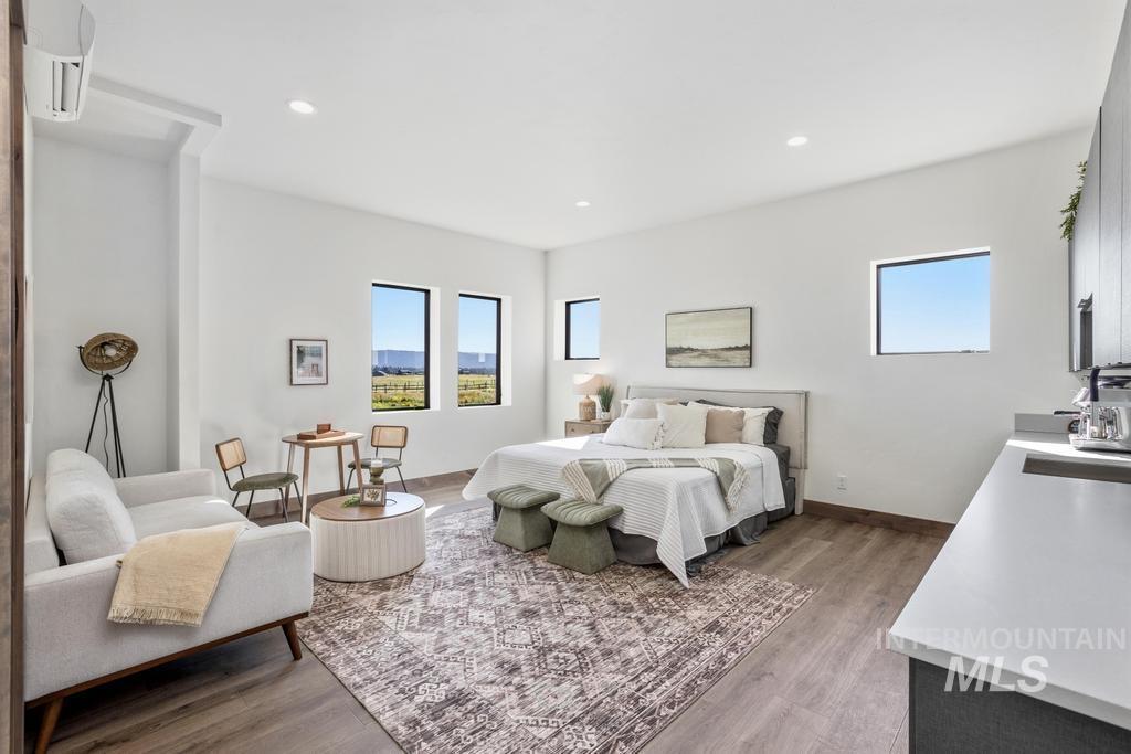 Spacious studio featuring wood-finish flooring and multiple windows