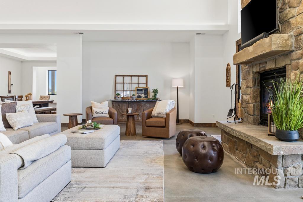 Spacious living area featuring a prominent stone fireplace with an integrated hearth and mantel