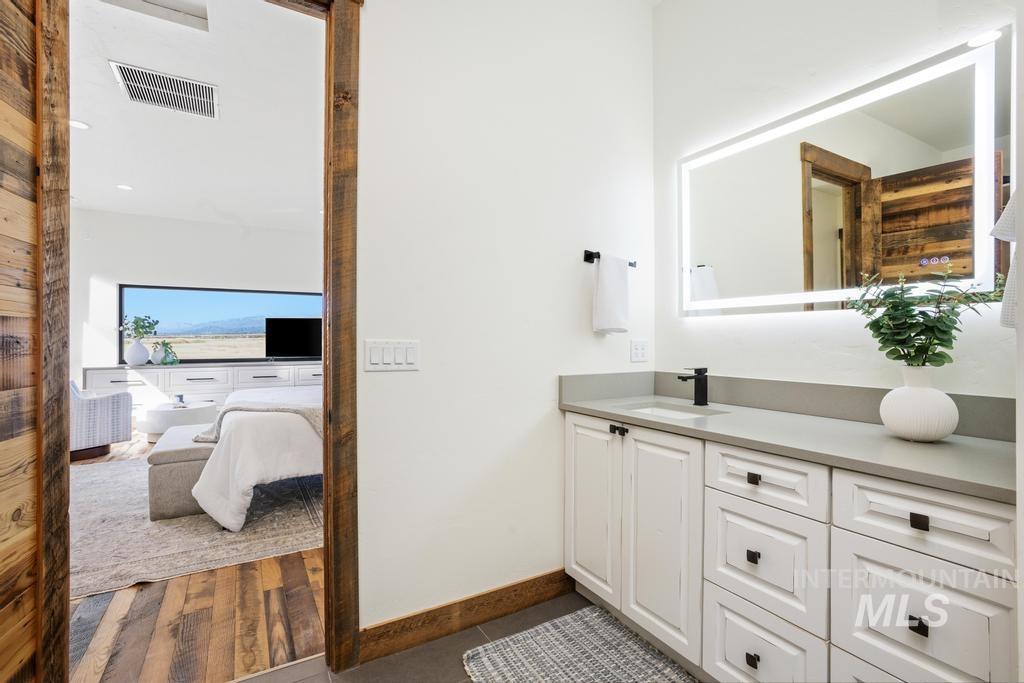 Vanity featuring a light-toned countertop, integrated sink, and matte black faucet