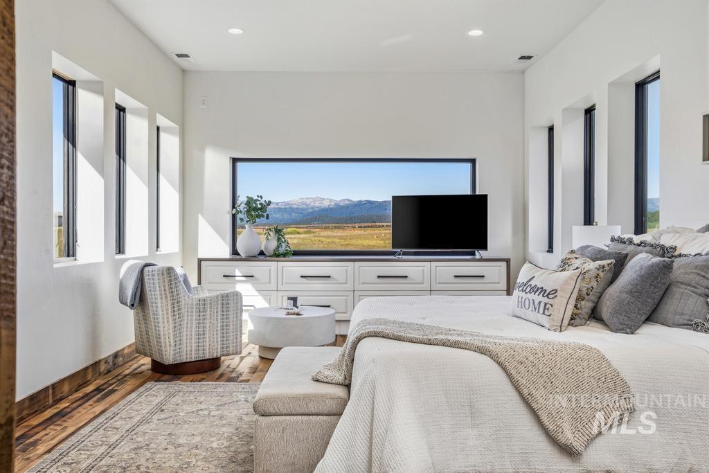 Room featuring a horizontal picture window showcasing a mountain and field landscape