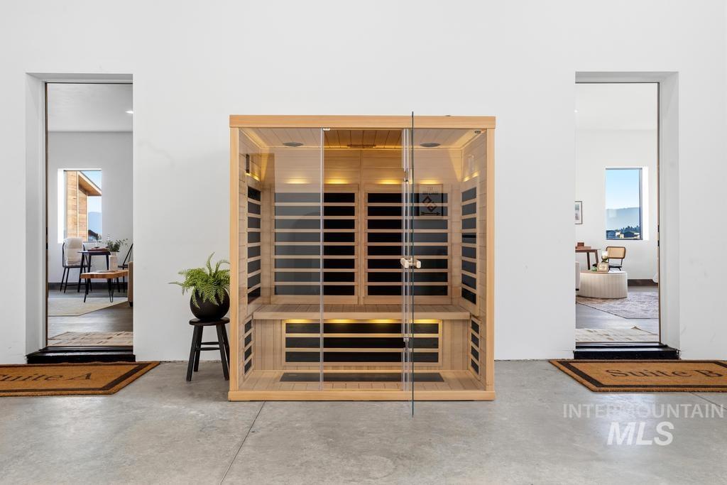 Freestanding sauna unit with light wood construction and clear glass door