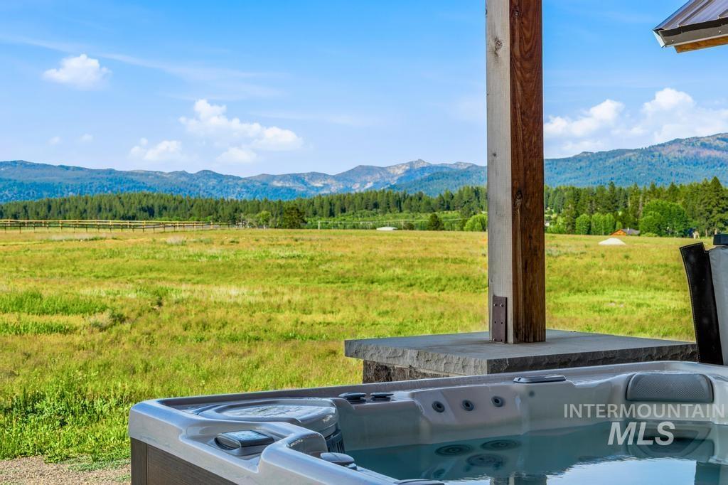 Outdoor spa tub on a stone patio featuring a wooden support beam