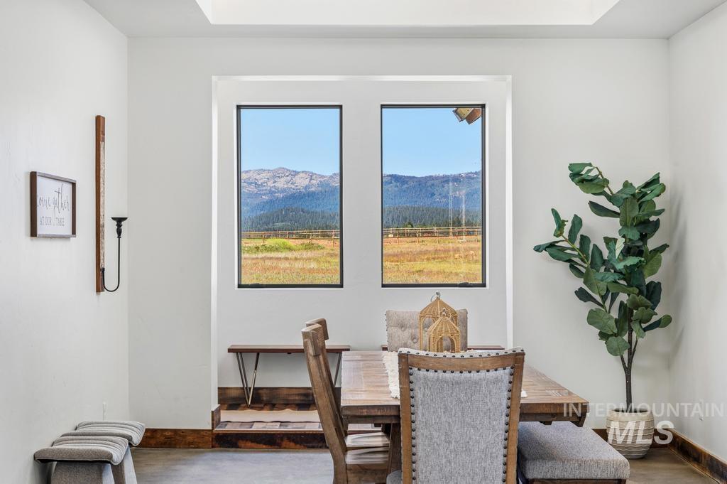 Dual picture windows with black framing highlight a mountain and field landscape